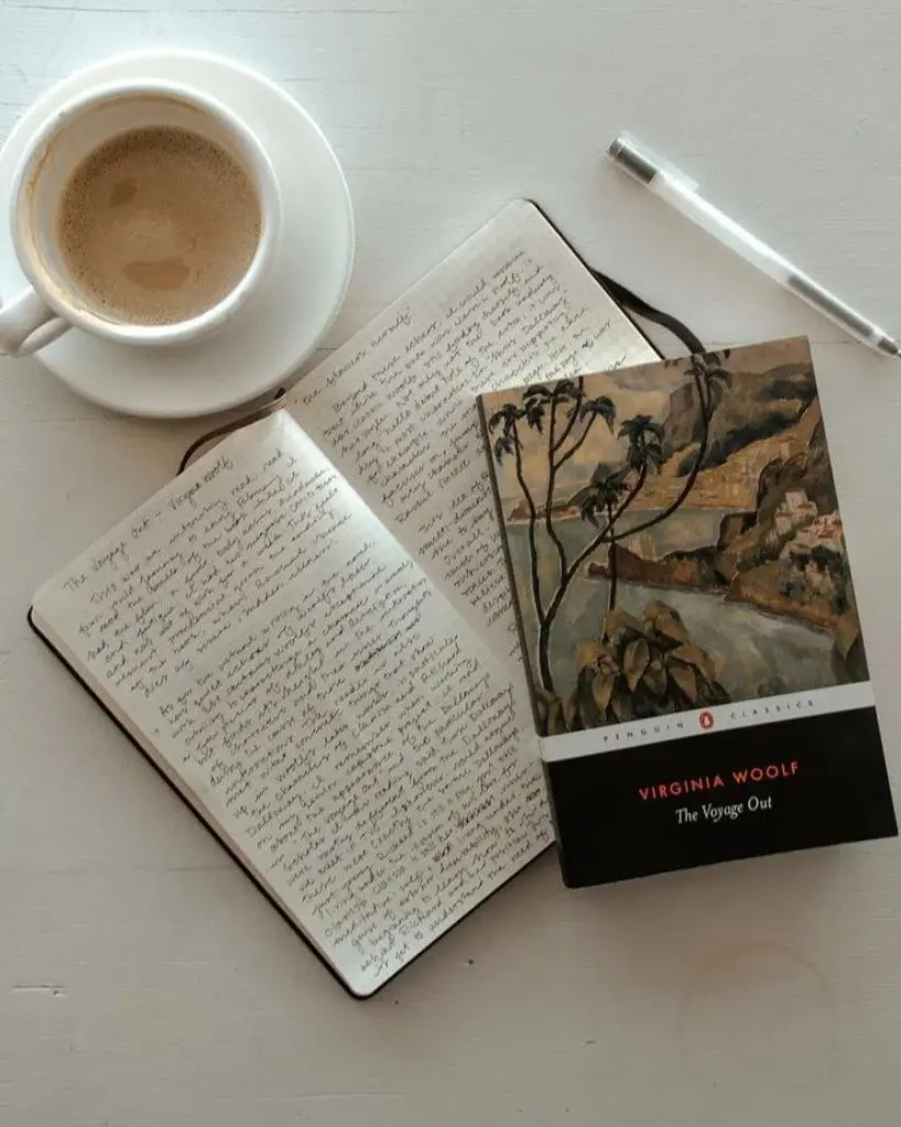 Poetcore open book next cup coffee pen white table